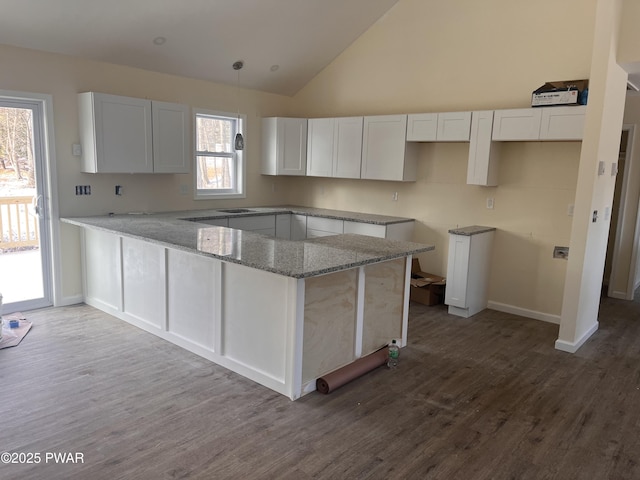 kitchen featuring kitchen peninsula, white cabinetry, and hanging light fixtures