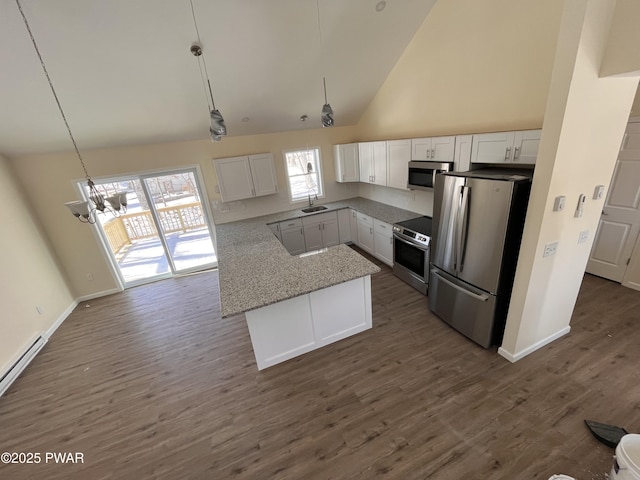 kitchen with hanging light fixtures, appliances with stainless steel finishes, high vaulted ceiling, and white cabinetry