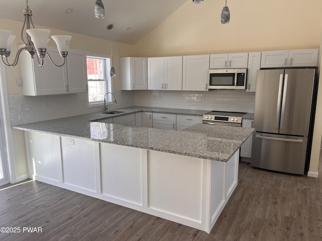 kitchen featuring light stone counters, a peninsula, a sink, white cabinets, and appliances with stainless steel finishes