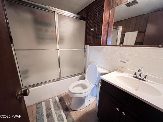124 Roundhill Rd, Dingmans Ferry, PA 18328 - full bath featuring tile walls, vanity, enclosed tub / shower combo, toilet, and tile patterned floors