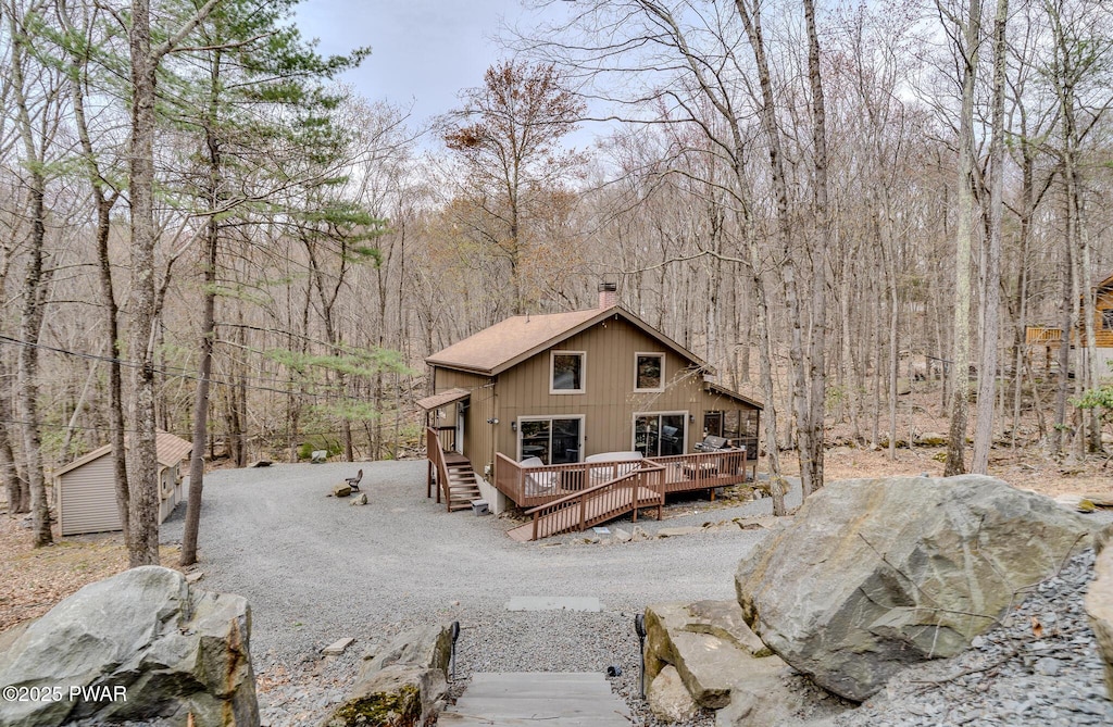 111 Butternut Ln, Greentown, PA 18426 - exterior space featuring an outbuilding, a chimney, a deck, and a forest view