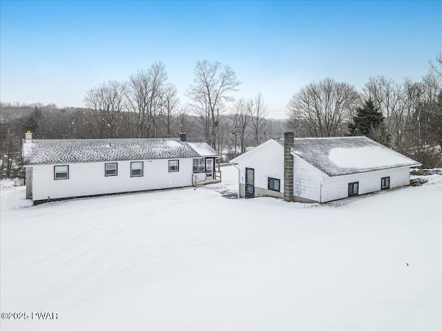 view of snow covered rear of property