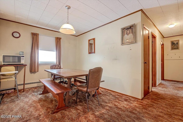 dining area featuring crown molding, a baseboard radiator, and carpet