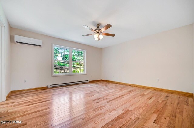 1202 Wallenpaupack Dr, Lake Ariel, PA 18436 - spare room featuring a baseboard heating unit, a wall mounted air conditioner, light wood-style flooring, ceiling fan, and baseboards