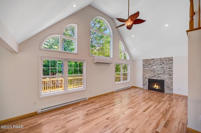 unfurnished living room featuring a stone fireplace, an AC wall unit, light wood-type flooring, and a baseboard radiator