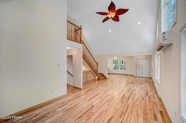 1202 Wallenpaupack Dr, Lake Ariel, PA 18436 - unfurnished living room featuring high vaulted ceiling, ceiling fan, stairway, light wood finished floors, and baseboard heating