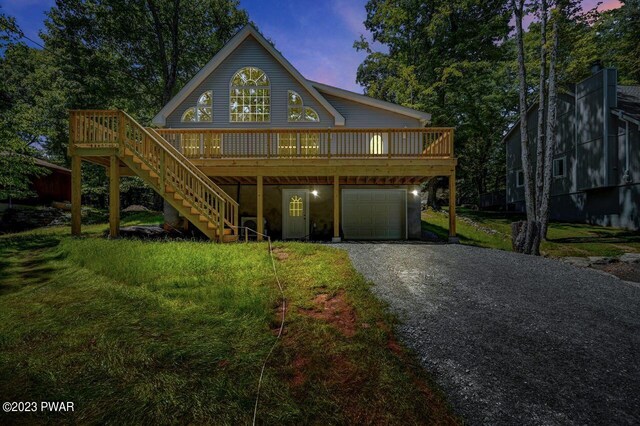 view of front of property featuring a lawn, a garage, and a deck