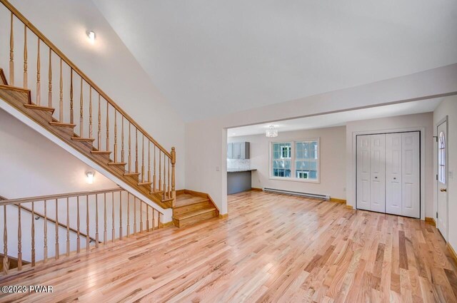 1202 Wallenpaupack Dr, Lake Ariel, PA 18436 - unfurnished living room with baseboard heating, wood finished floors, stairs, and baseboards