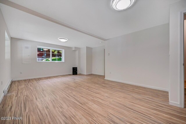 unfurnished living room featuring light hardwood / wood-style floors and a baseboard heating unit