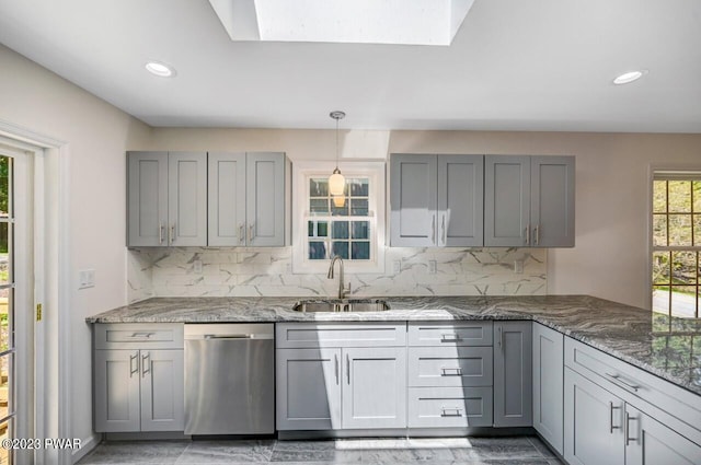 kitchen with dishwasher, decorative backsplash, a skylight, and sink