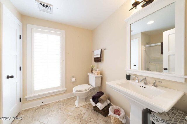 bathroom featuring toilet and a shower with door