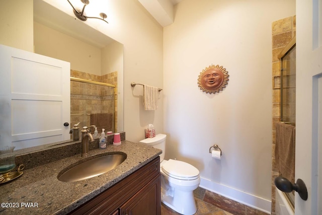 bathroom featuring a shower with door, vanity, and toilet