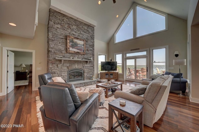 living room featuring a stone fireplace, high vaulted ceiling, and dark wood-type flooring