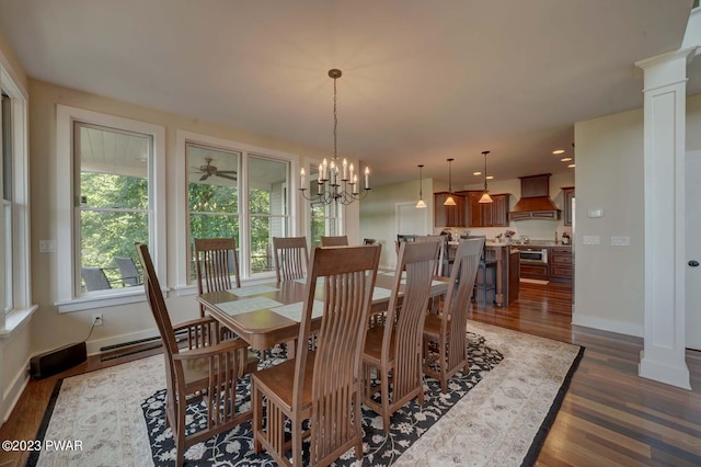 dining area with dark wood-type flooring, decorative columns, and a notable chandelier