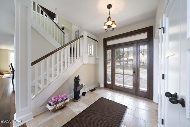 entrance foyer featuring a chandelier, french doors, and a healthy amount of sunlight