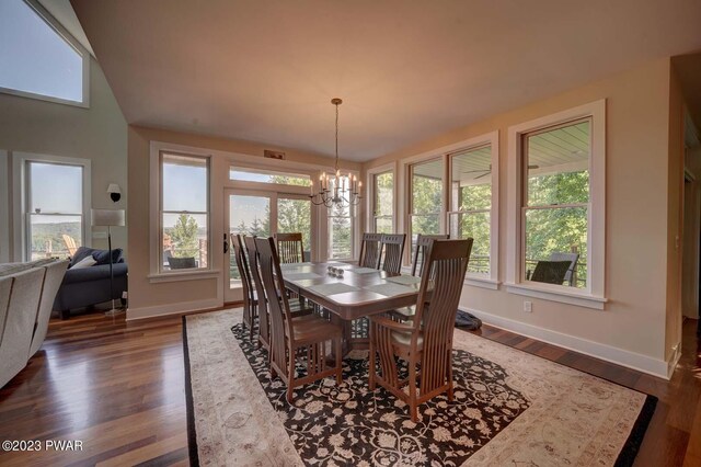 dining space with dark wood-type flooring and a notable chandelier