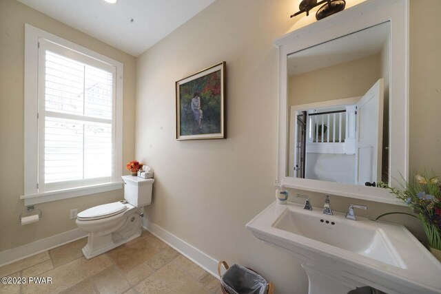 bathroom featuring a wealth of natural light, sink, and toilet