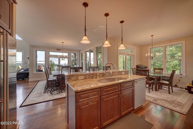 kitchen featuring an inviting chandelier, hanging light fixtures, sink, an island with sink, and appliances with stainless steel finishes