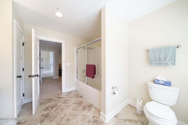 bathroom with bath / shower combo with glass door and toilet