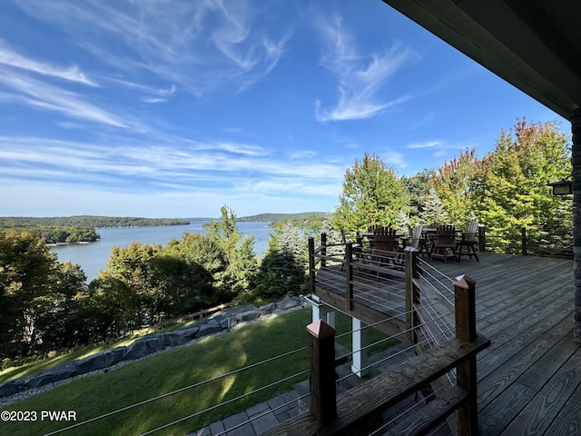 wooden deck featuring a lawn and a water view