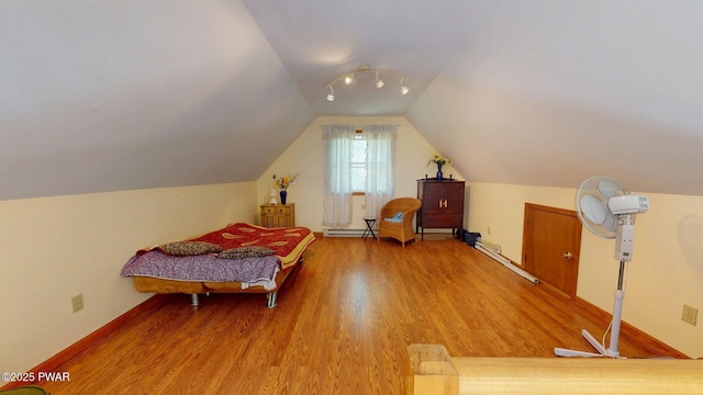 216 Westfall Dr, Dingmans Ferry, PA 18328 - bedroom featuring wood finished floors, vaulted ceiling, and a baseboard heating unit