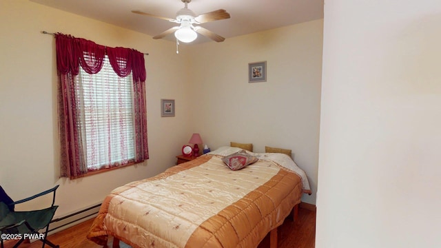 216 Westfall Dr, Dingmans Ferry, PA 18328 - bedroom featuring a baseboard heating unit, wood finished floors, and a ceiling fan