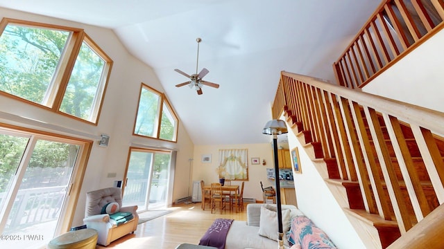 216 Westfall Dr, Dingmans Ferry, PA 18328 - living room with high vaulted ceiling, stairs, wood finished floors, and ceiling fan