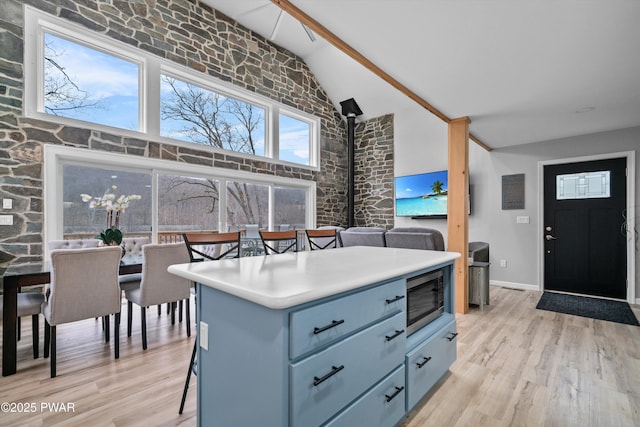 111 Riverbend Ln, Beach Lake, PA 18405 - kitchen featuring light wood-type flooring, high vaulted ceiling, stainless steel microwave, and blue cabinetry