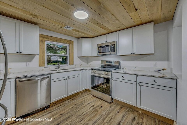 28 Holland Rd, Hawley, PA 18428 - kitchen featuring appliances with stainless steel finishes, wood ceiling, light wood-type flooring, light stone counters, and white cabinetry