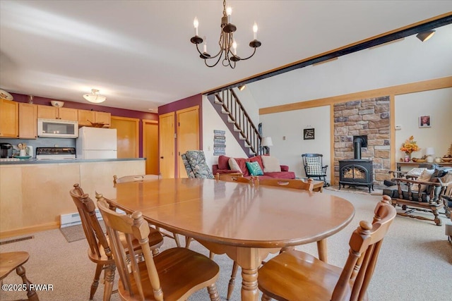 dining area with stairway, visible vents, a wood stove, and light colored carpet