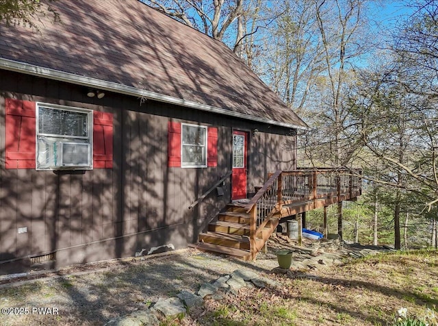 exterior space with a shingled roof and a wooden deck