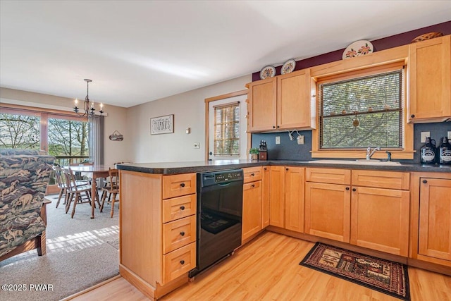 kitchen with an inviting chandelier, plenty of natural light, a sink, light wood-style flooring, and dishwasher