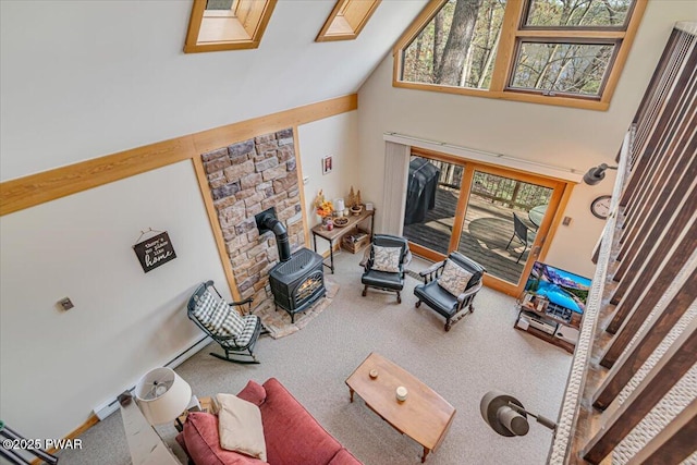 carpeted living area featuring a wood stove and high vaulted ceiling