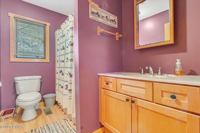 full bath with vanity, toilet, a shower with shower curtain, wood finished floors, and visible vents