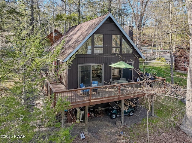 back of property featuring a wooden deck and a chimney