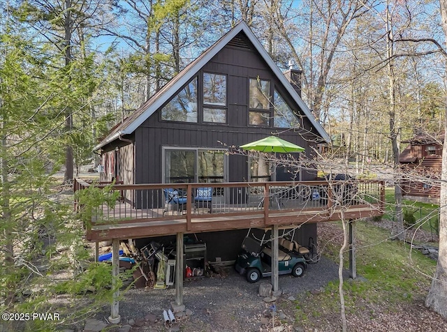 rear view of house featuring a chimney and a deck