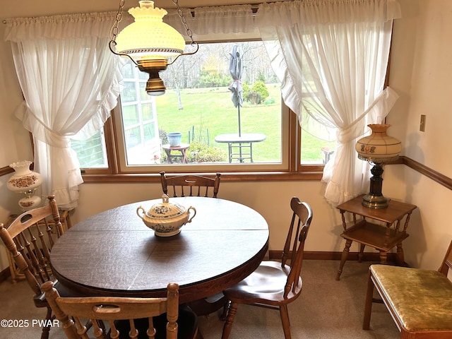 carpeted dining area featuring baseboards