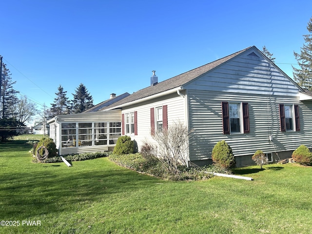 rear view of property with a yard and a sunroom