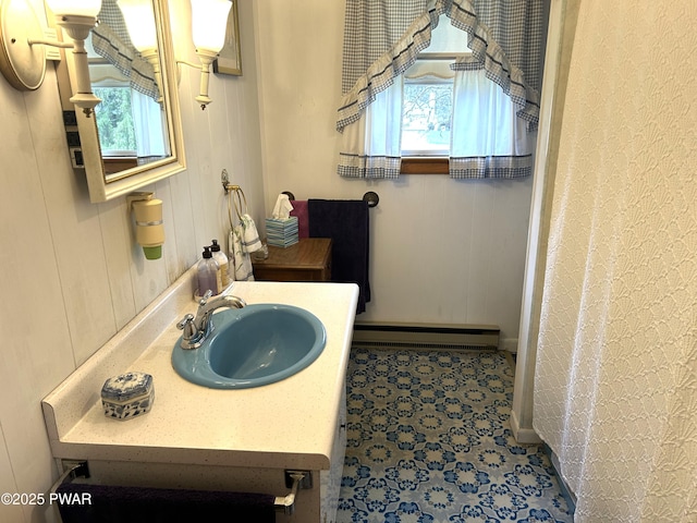 bathroom with baseboards, plenty of natural light, vanity, and a baseboard radiator