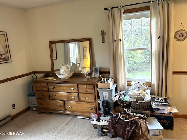carpeted bedroom with a baseboard radiator, baseboards, and multiple windows
