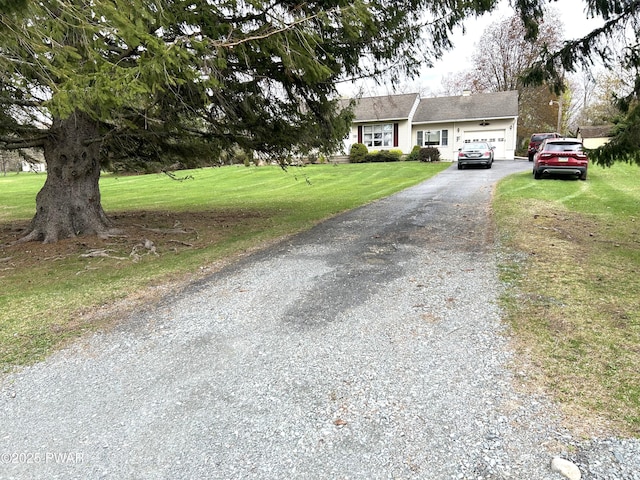 view of front of property with aphalt driveway, a front lawn, and an attached garage