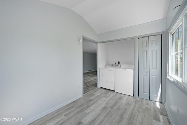 clothes washing area featuring baseboards, laundry area, washing machine and dryer, and light wood-type flooring