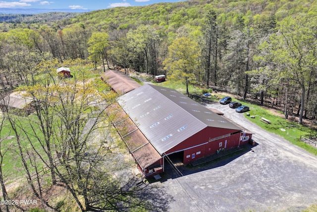 bird's eye view with a wooded view