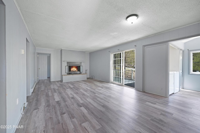 unfurnished living room featuring a textured ceiling, a wealth of natural light, and wood finished floors