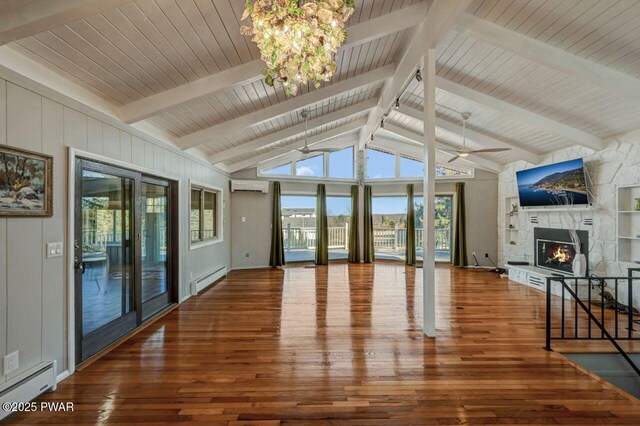 unfurnished living room with a baseboard heating unit, wood-type flooring, a fireplace, and a wall unit AC