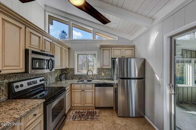 kitchen with vaulted ceiling with beams, light stone countertops, decorative backsplash, stainless steel appliances, and a sink