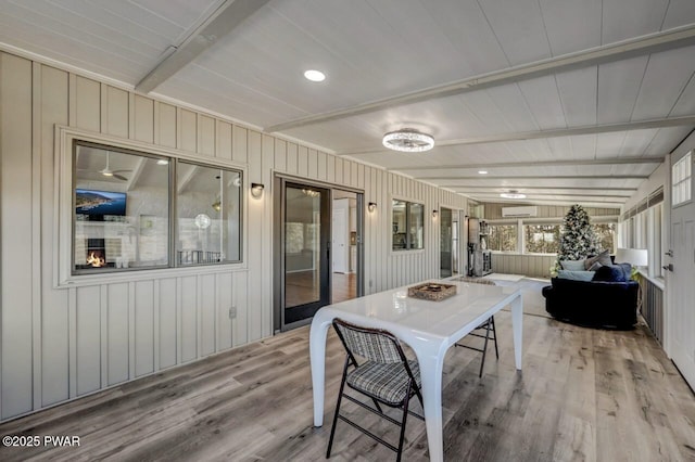 sunroom with beam ceiling and a wall unit AC