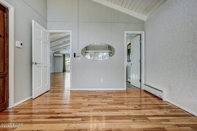 interior space featuring light wood-type flooring, wooden ceiling, a baseboard radiator, baseboards, and vaulted ceiling with beams