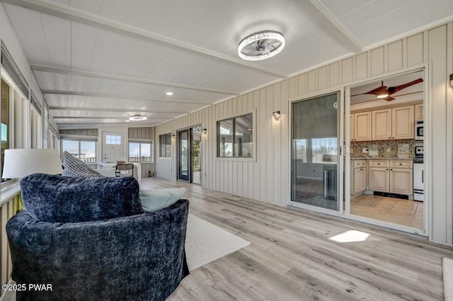 living room featuring beamed ceiling and light wood finished floors