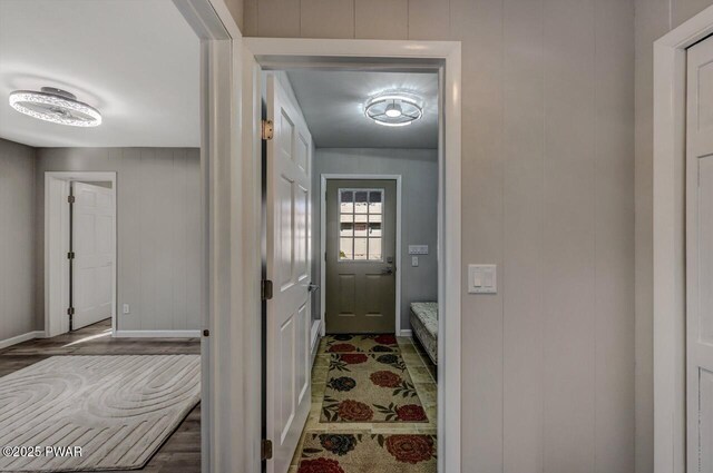 doorway to outside featuring wood finished floors and baseboards